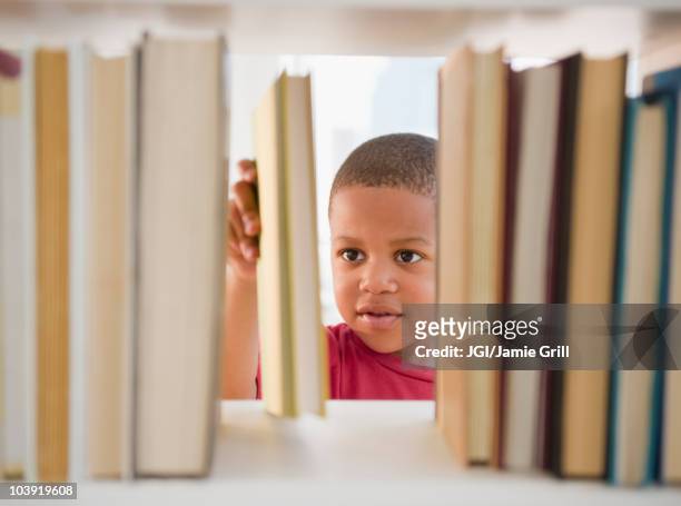 african american boy selecting book - shelf strip stock pictures, royalty-free photos & images