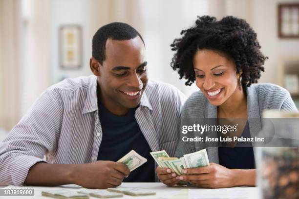 couple counting money - couple counting money stock pictures, royalty-free photos & images