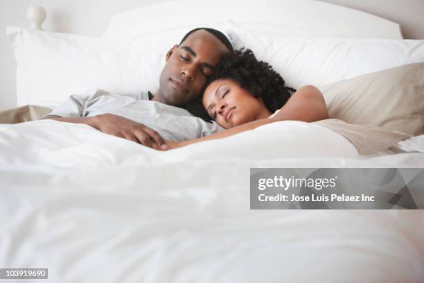 couple sleeping in bed - black man sleeping in bed stock pictures, royalty-free photos & images