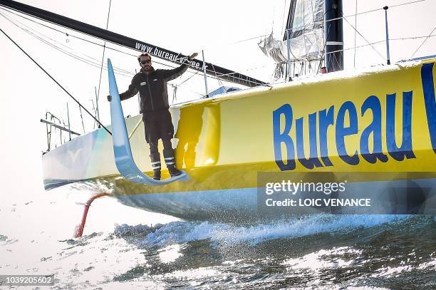 French sailor Louis Burton poses standing on a foil of his Imoca 60 monohull Bureau Vallee, as he sails from Lorient to Saint-Malo, on September 24 a...