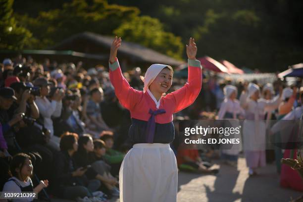 Performers take part in a traditional dance at the Namsangol hanok village in Seoul on September 24, 2018. - South Koreans are observing the annual...