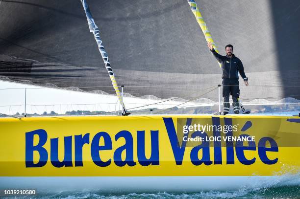 French sailor Louis Burton poses standing on a foil of his Imoca 60 monohull Bureau Vallee, as he sails from Lorient to Saint-Malo, on September 24 a...