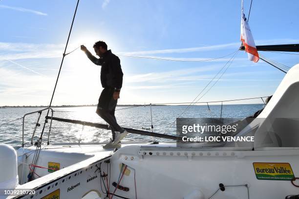 French sailor Louis Burton poses standing on a foil of his Imoca 60 monohull Bureau Vallee, as he sails from Lorient to Saint-Malo, on September 24 a...