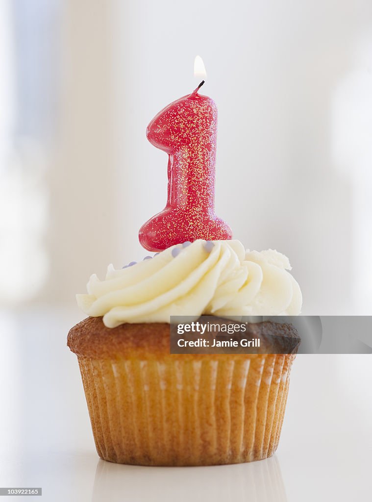 Lit candle on cupcake for first birthday celebration