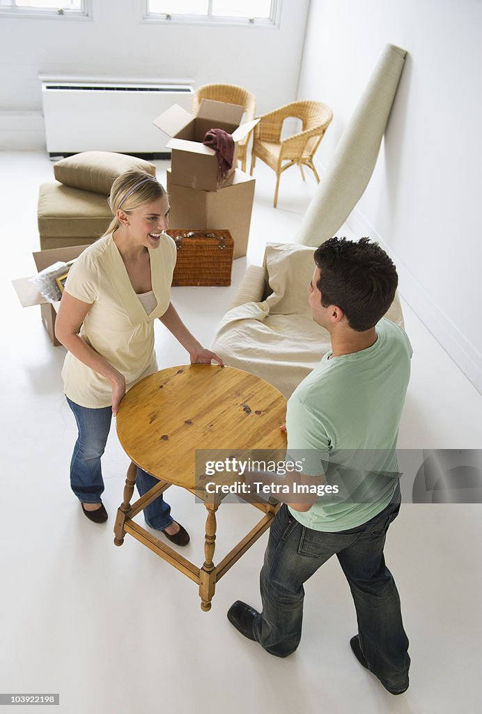 Couple moving furniture in their new home