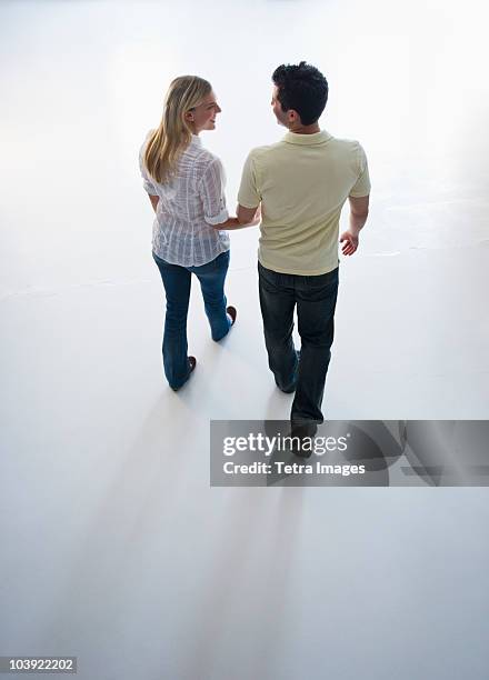 happy couple walking hand in hand - couple walk white background stock pictures, royalty-free photos & images