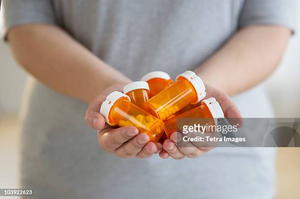 hands holding several bottles of prescription medication - diabetes pills stock pictures, royalty-free photos & images