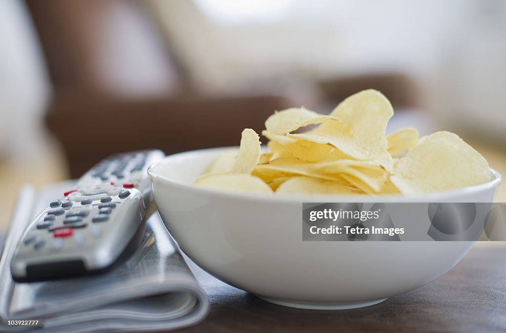 Bowl of chips beside remote control