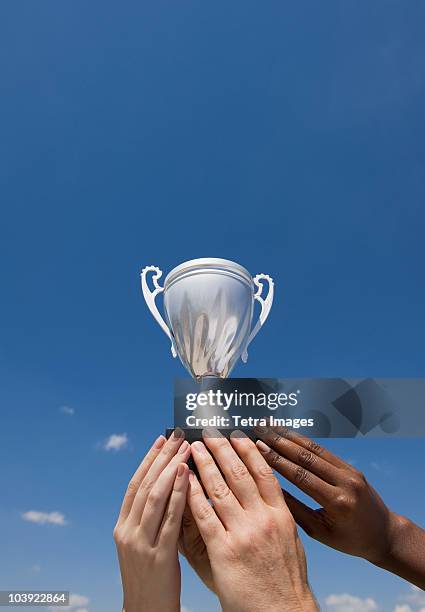 hands holding trophy in the air - holding trophy stockfoto's en -beelden