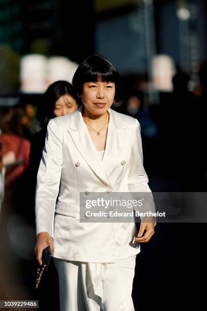 Angelica Cheung wears a white blazer jacket, during London Fashion Week September 2018 on September 17, 2018 in London, England.