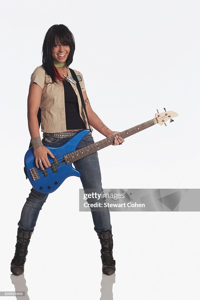 Teenage girl playing electric guitar