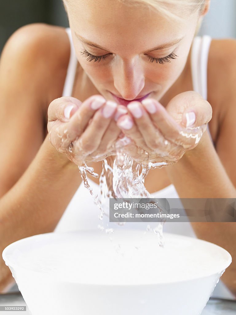 Woman splashing water on her face