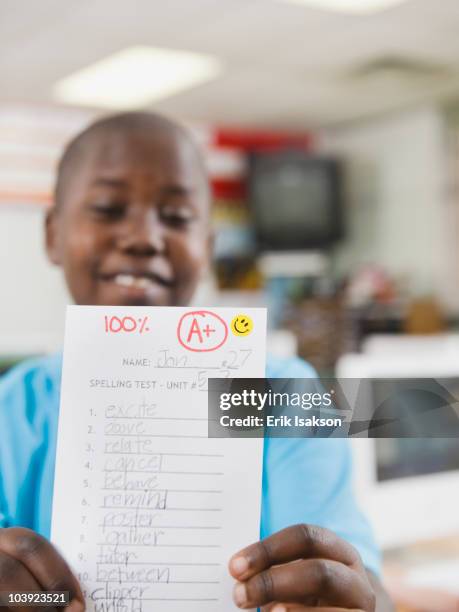 elementary student holding an a grade paper - good grades stock pictures, royalty-free photos & images