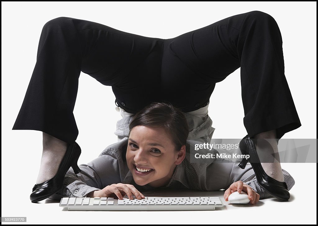 Businesswoman contorting her body while typing