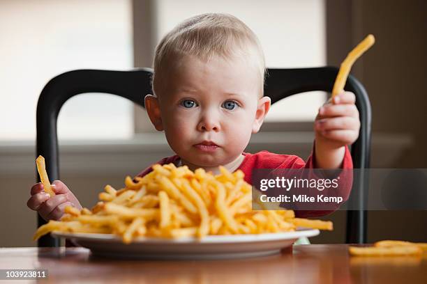 toddler eating a large plate of french fries - chunky chips stock pictures, royalty-free photos & images