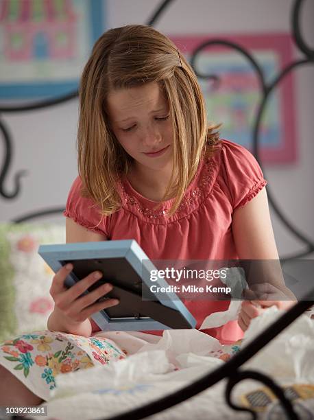 young girl crying while looking at photograph - child death stock pictures, royalty-free photos & images