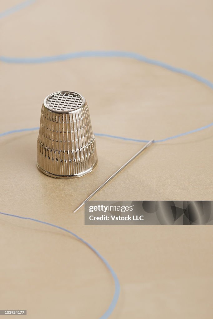 Thimble and threaded needle