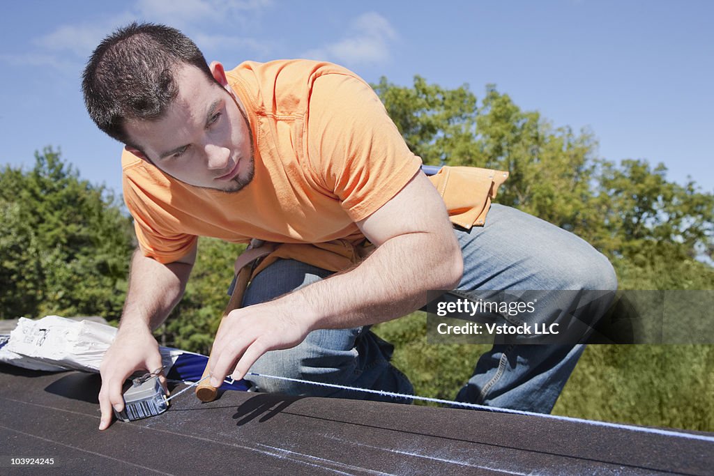 Man measuring with chalk dust on roof