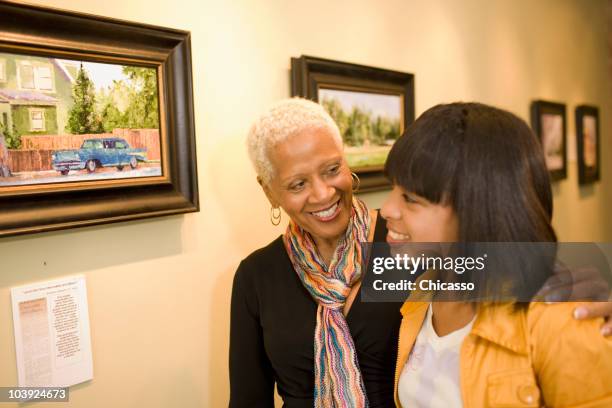 grandmother and granddaughter hugging in gallery - painting art product stock pictures, royalty-free photos & images