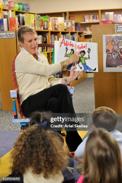 caucasian teacher teaching spanish with book in library - spanish language stockfoto's en -beelden