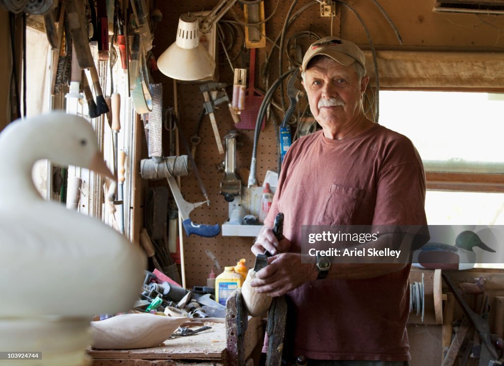 Caucasian man carving duck decoy