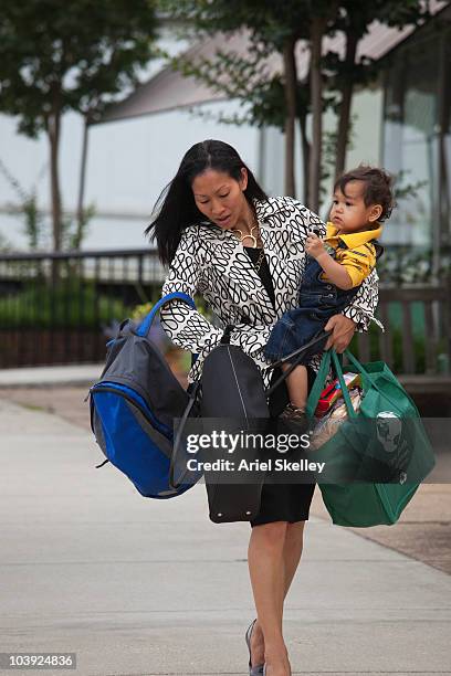 asian woman carrying baby and bags - heavy rucksack stock pictures, royalty-free photos & images