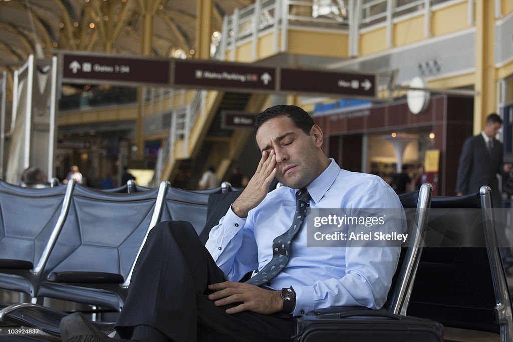 Tired Hispanic business traveler in airport