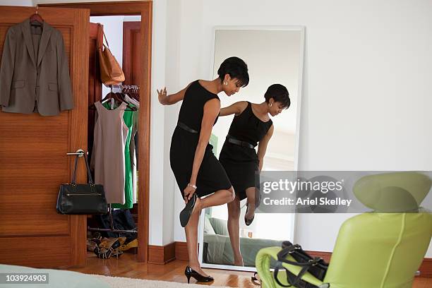 african american woman dressing in bedroom - black shoe stock-fotos und bilder