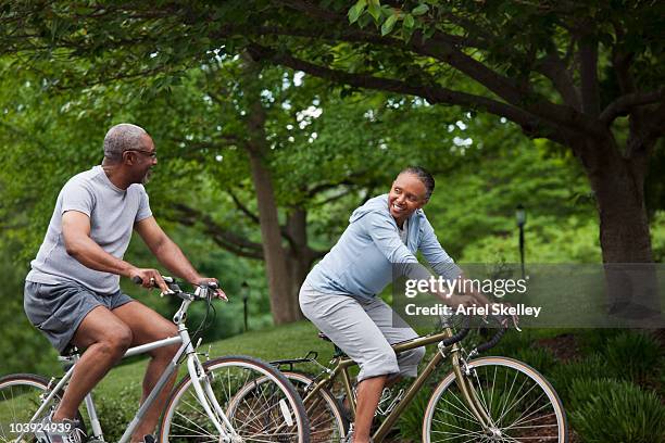 black couple riding bicycles - fun couple on bike stock-fotos und bilder