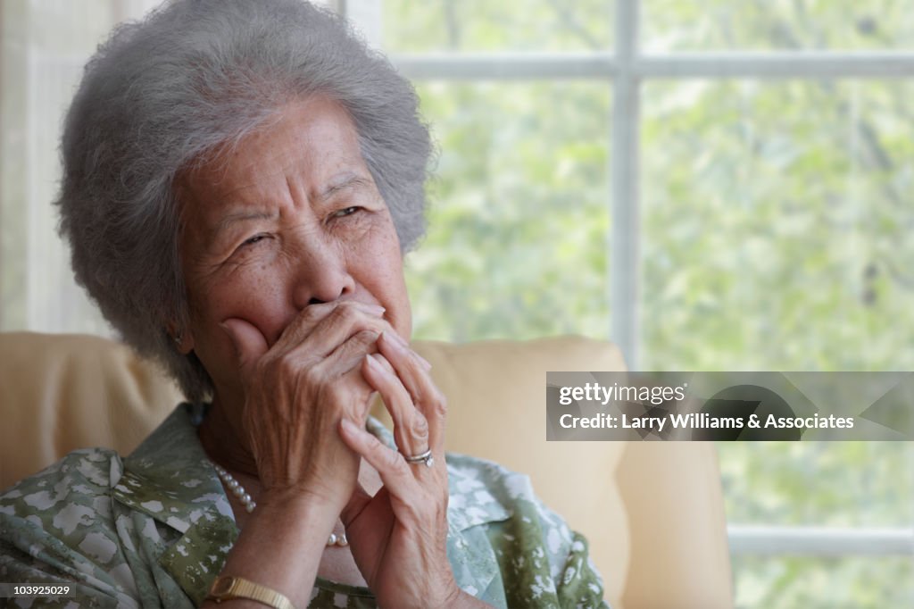 Asian woman covering mouth with hand