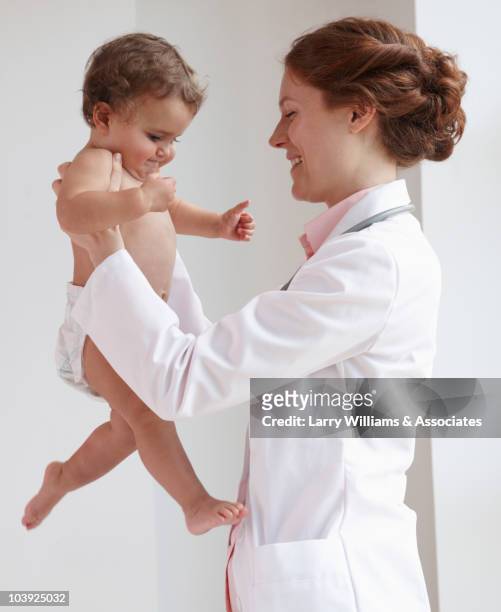 pediatrician lifting child - clinic canada diversity stock-fotos und bilder