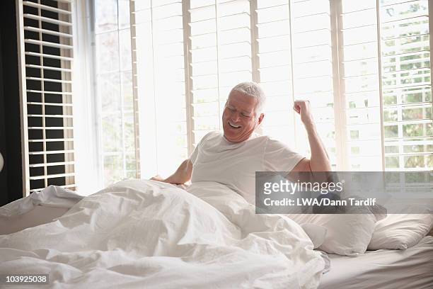 caucasian man waking in bed - morning bed stretch fotografías e imágenes de stock