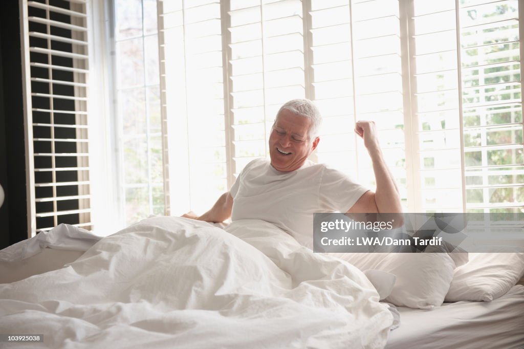 Caucasian man waking in bed