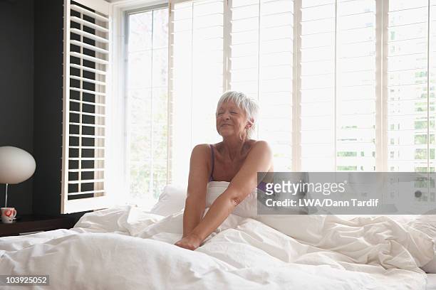 caucasian woman waking in bed - old bed stockfoto's en -beelden