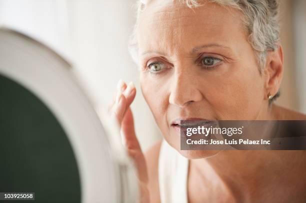 african american woman applying makeup - gesichtscreme stock-fotos und bilder