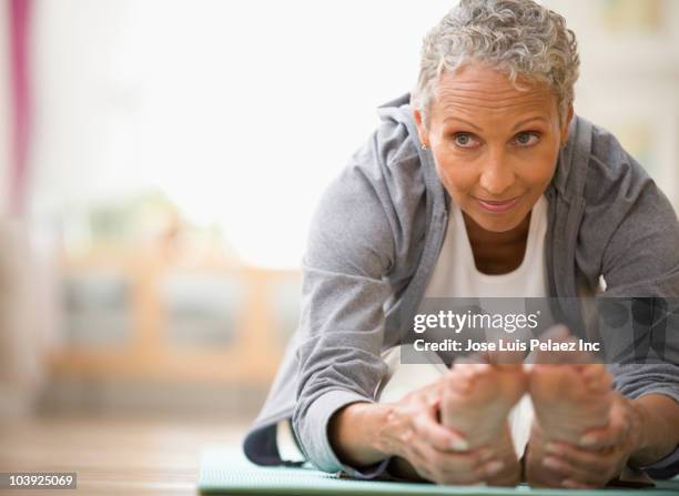 african american woman stretching - senior yoga stock pictures, royalty-free photos & images