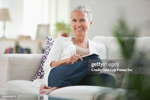 african american woman watching television on sofa - arts express yourself 2009 stock pictures, royalty-free photos & images