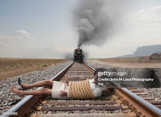 black businesswoman tied to train tracks - tangled stock pictures, royalty-free photos & images