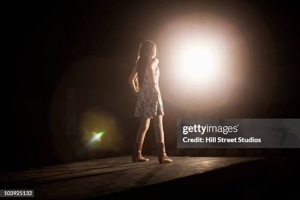 model in spotlight on fashion runway - trade show stockfoto's en -beelden