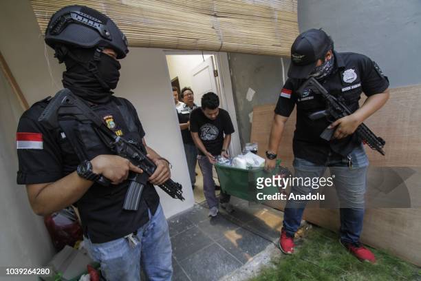 Officers bring collected evidence in an operation on an ecstasy factory at Sentra Pondok Rajeg Housing, in Cibinong, Bogor, West Java, Indonesia on...