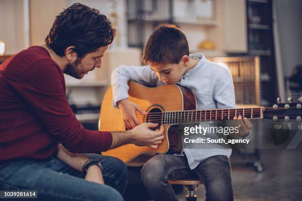 young boy teaching to play guitar - classroom play stock pictures, royalty-free photos & images