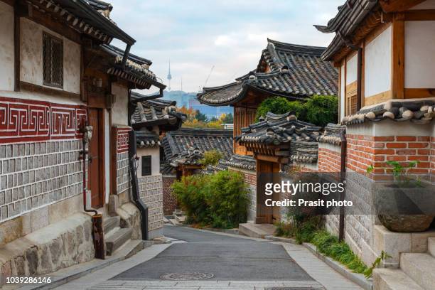 traditional korean style architecture at bukchon hanok village with n seoul tower in background in seoul, south korea. - corea del sur fotografías e imágenes de stock