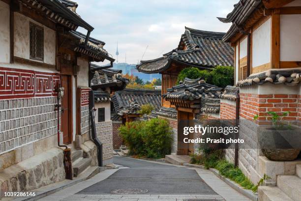 traditional korean style architecture at bukchon hanok village with n seoul tower in background in seoul, south korea. - south corea foto e immagini stock