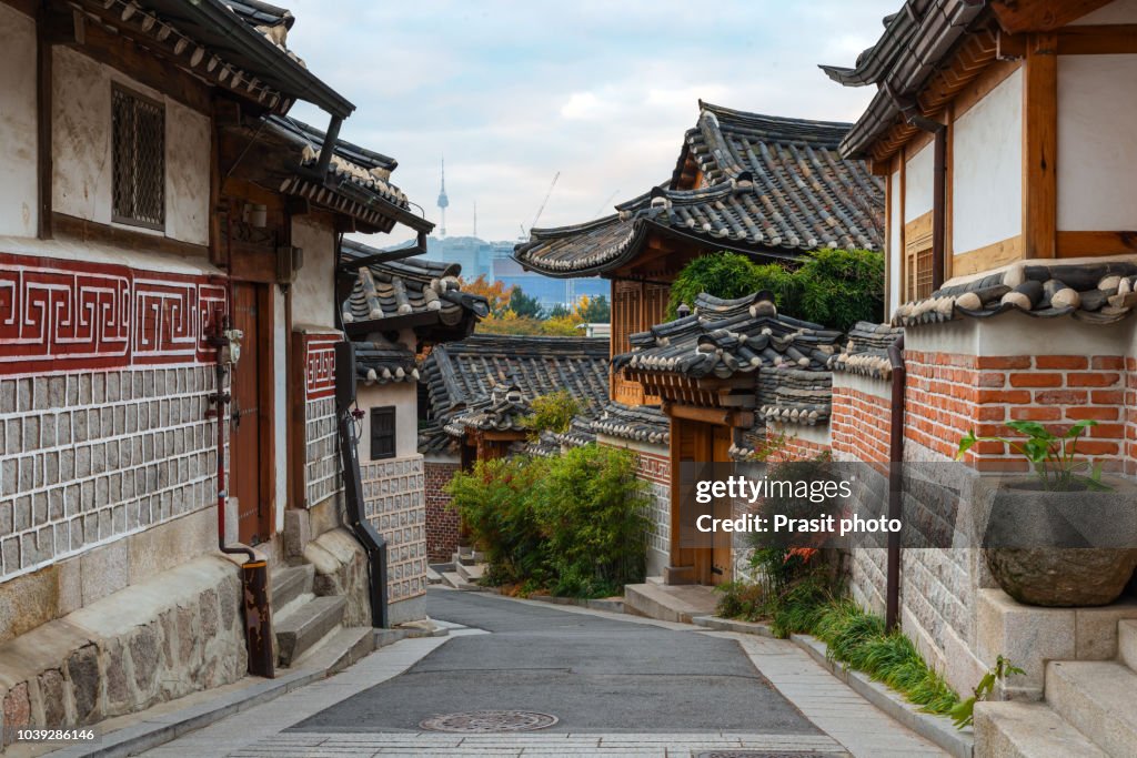 Traditional Korean style architecture at Bukchon Hanok Village with N Seoul Tower in background in Seoul, South Korea.