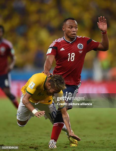Neymar of Brazil and Juan Zuniga of Colombia vie for the ball during the FIFA World Cup 2014 quarter final match soccer between Brazil and Colombia...