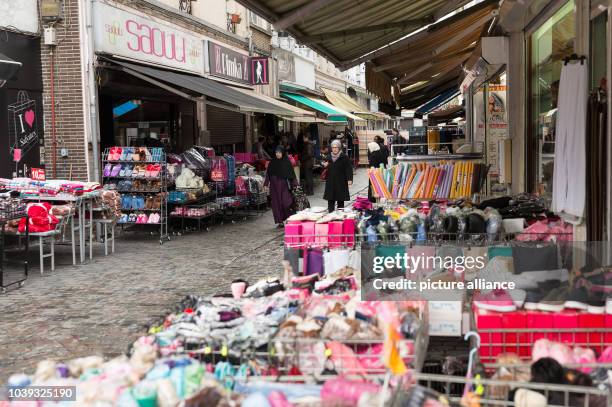 Only a few people walk along the Rue du Prado shopping street in the district of Molenbeek in Brussels, Belgium, 17 November 2015. The Arab...