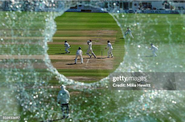 Mal Loye of Northamptonshire hits a boundary as seen through the hole in the press box window that he created with an earlier six, during the LV...