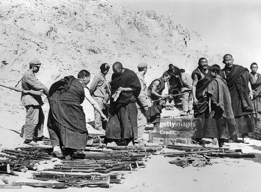 Tibetan monks, surrounded by soldiers of