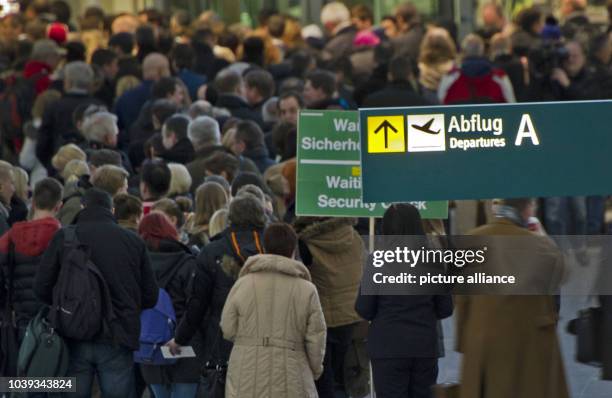 Passengers queue in front of the security check at the airport in Duesseldorf, Germany, 15 March 2013. Passengers at the airports in Duesseldorf and...