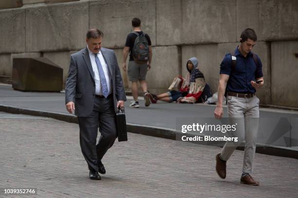 Pedestrians walking along Nassau Street near the New York Stock Exchange in New York, U.S., on Monday, Sept. 24, 2018. U.S. Stocks fell to their lows...
